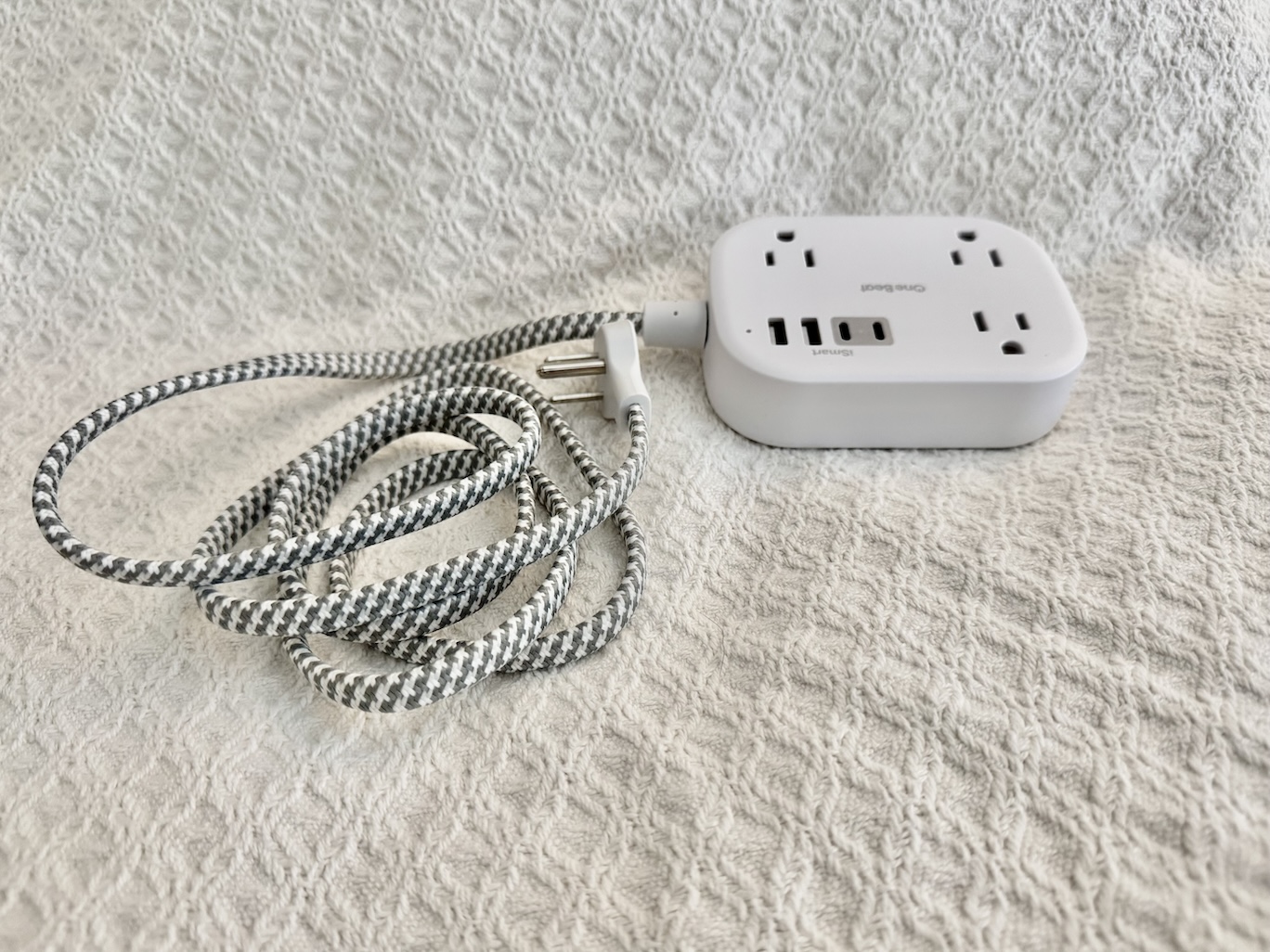 Image of a cruise-safe power strip with multiple outlets and USB ports, specifically designed for cruise ship use. The power strip is compact and features a white or black casing with no surge protection, making it compliant with cruise line regulations. It includes several standard outlets and a few USB charging ports, allowing for the simultaneous charging of various devices like phones, tablets, and cameras while on board. The power strip is shown placed on a flat surface, with its features clearly visible.