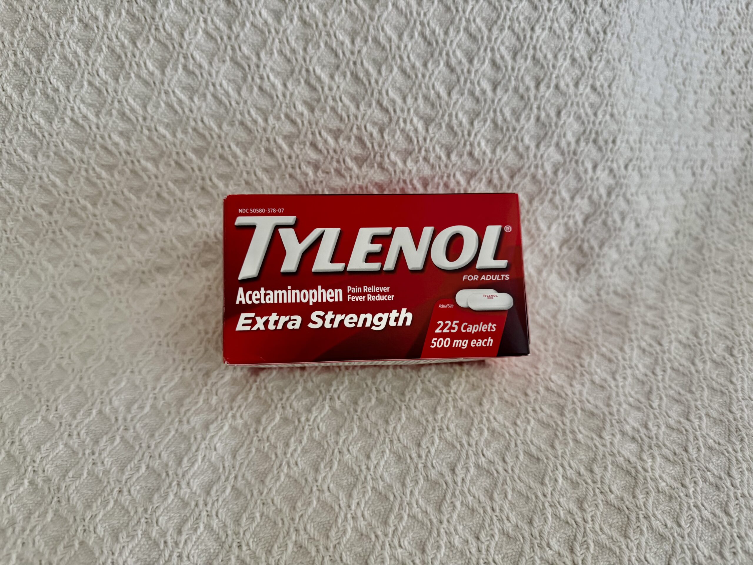 Image of a bottle of Tylenol Extra Strength Caplets, containing 225 count. The bottle is white with a red label that prominently displays the Tylenol brand name and 'Extra Strength' in bold lettering. The label also indicates the dosage of 500 mg per caplet and highlights its use for pain relief and fever reduction. The cap is child-resistant, and the bottle is shown against a neutral background, clearly presenting the product's details.